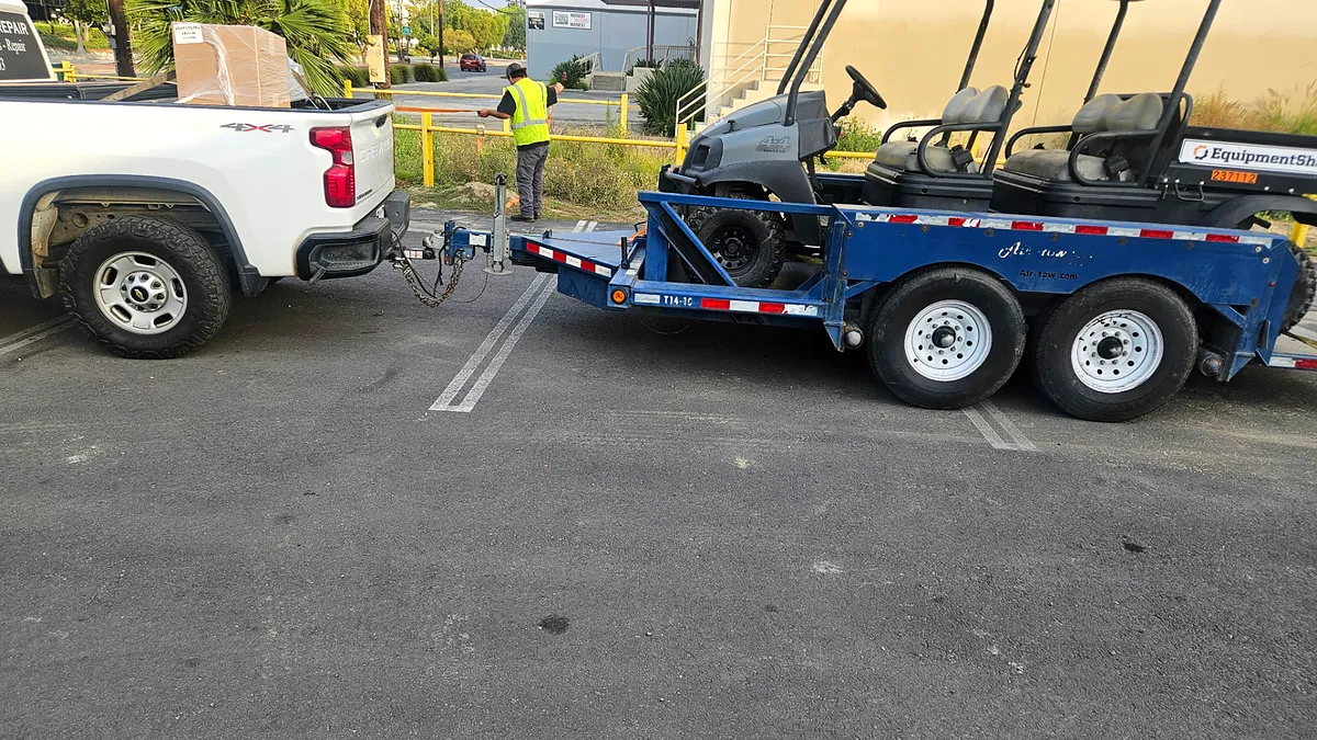 Service truck and trailer hauling customer equipment