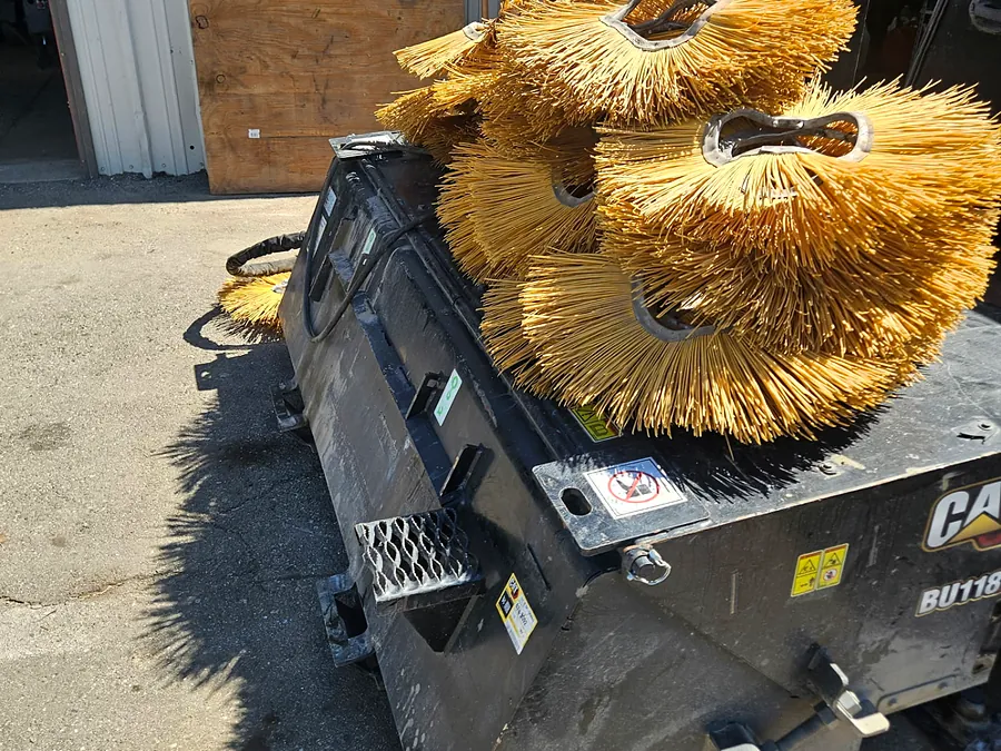 CAT broom attachment and brush assemblies staged for service
